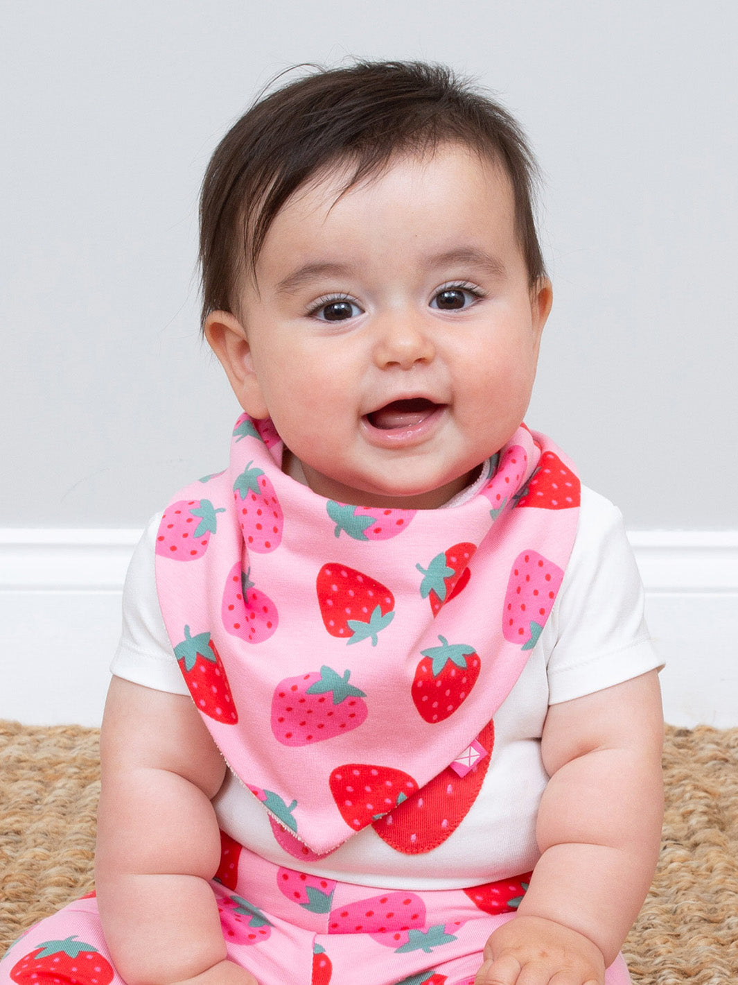 Baby wearing a pink bib with strawberry pattern on a plain background
Baby accessories
Bib
Organic cotton
GOTS Certified fabric
New baby gift
Baby Shower