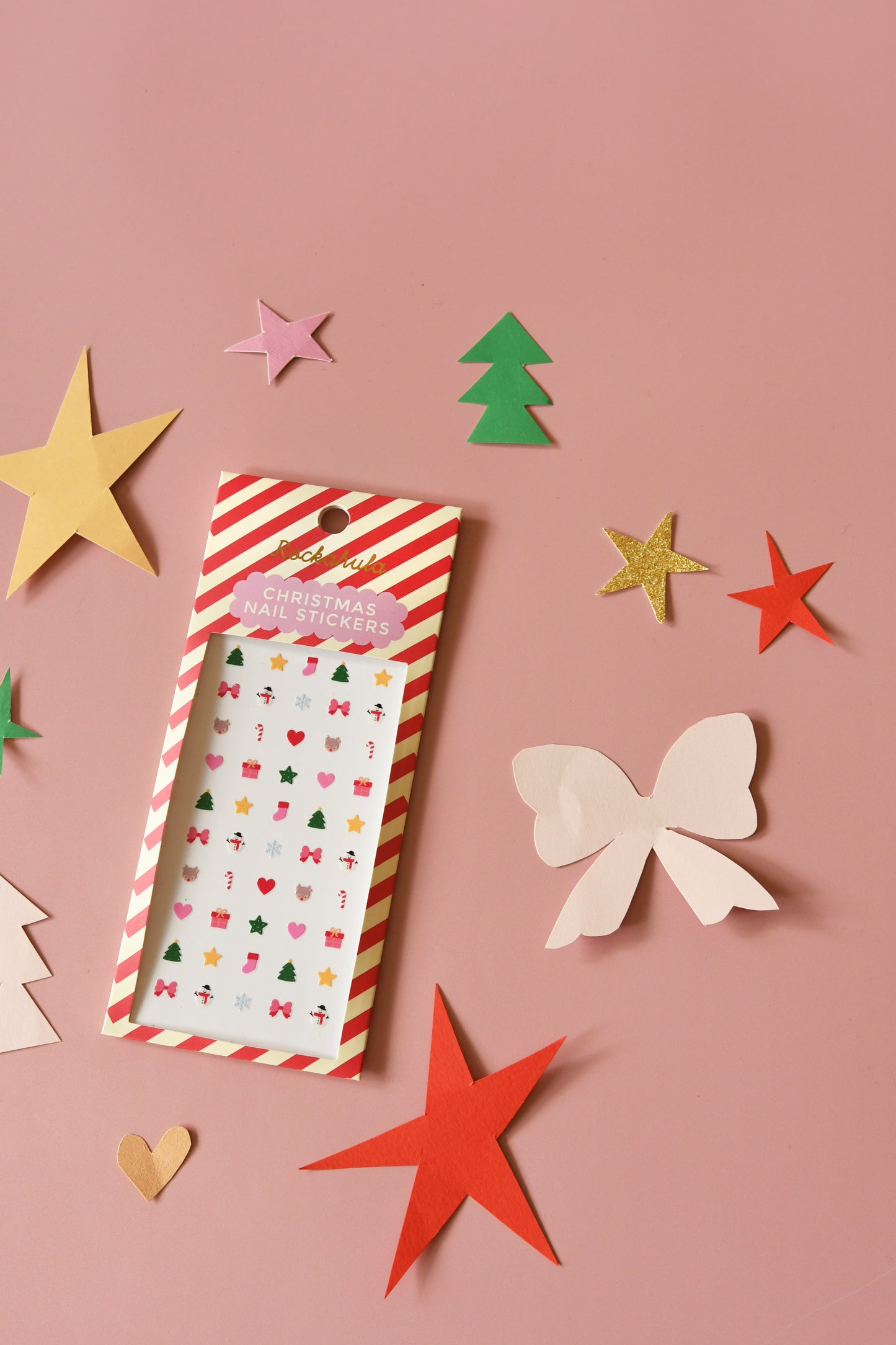 Pack of decorative stickers with festive designs on a pink background with paper cutout shapes.