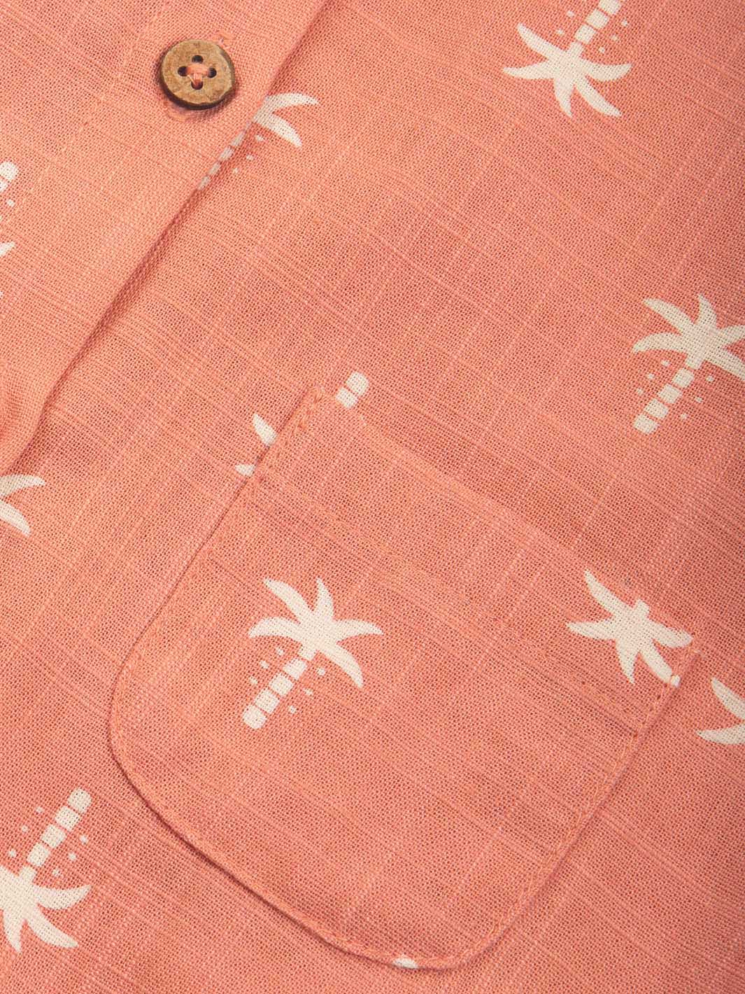 Close-up of a pair of baby dungarees with palm tree patterns