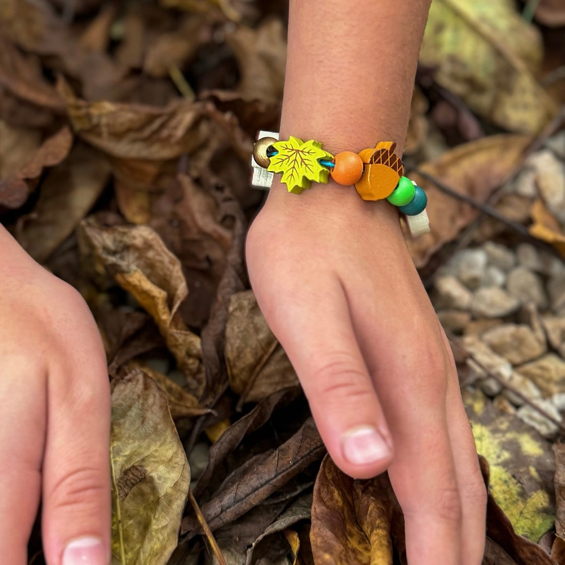 Child wearing our Make Your Own Forest Bracelet in the woods