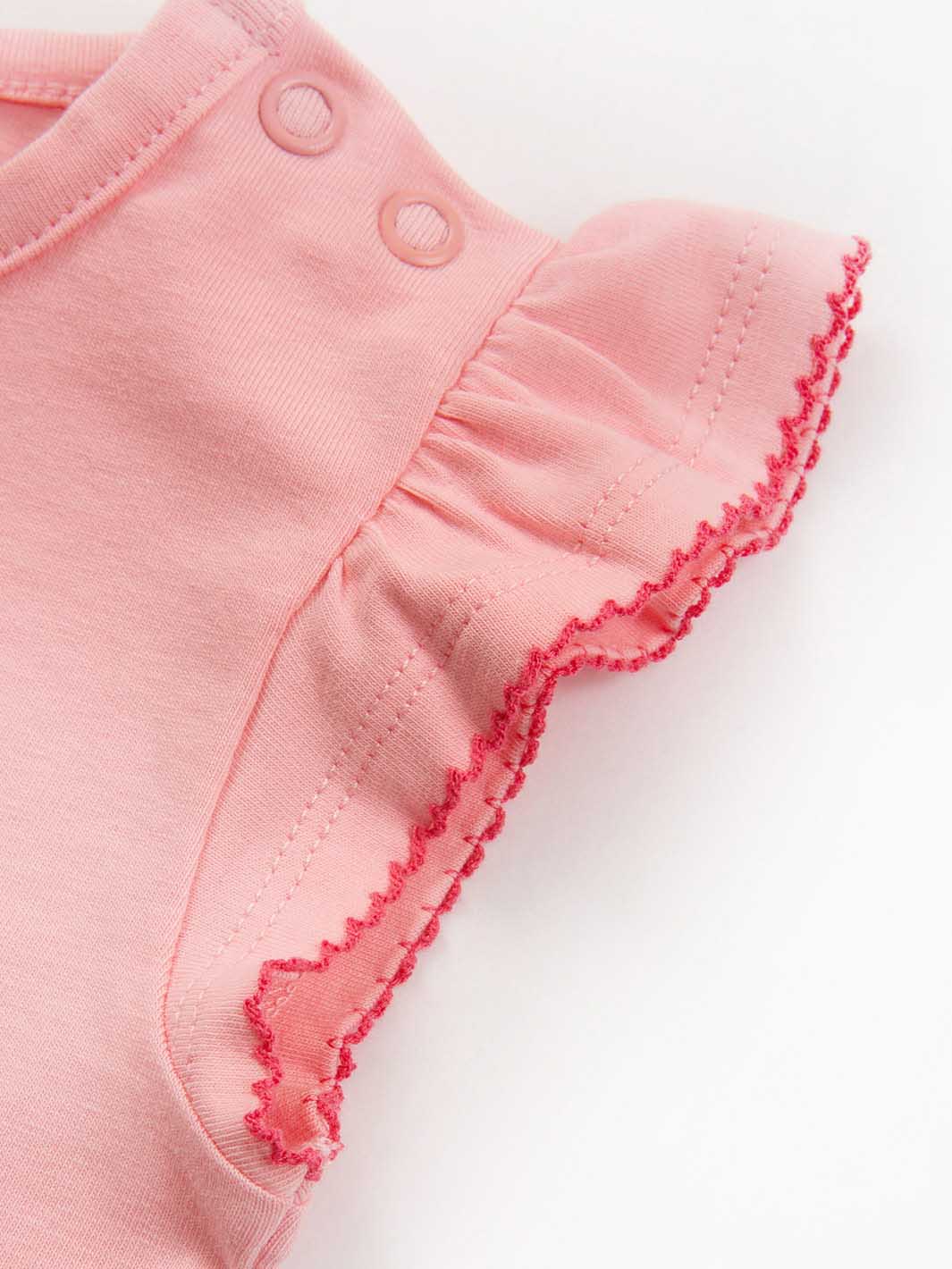 Close-up of pink bodysuit with ruffled edge on a white background