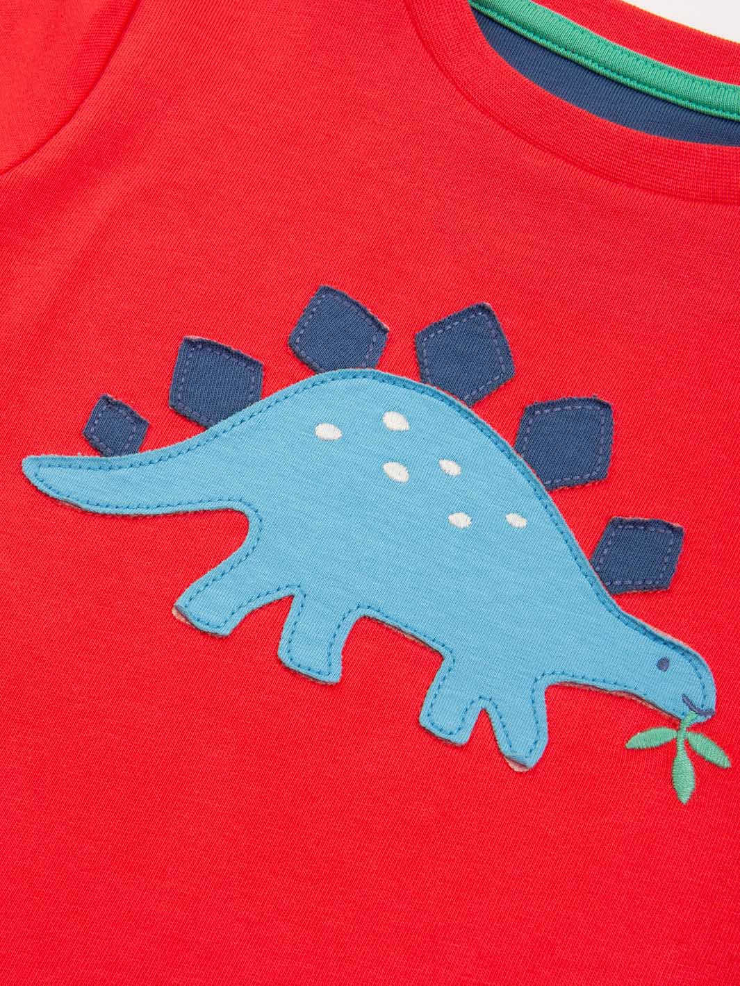 Red shirt with blue dinosaur design on a plain background