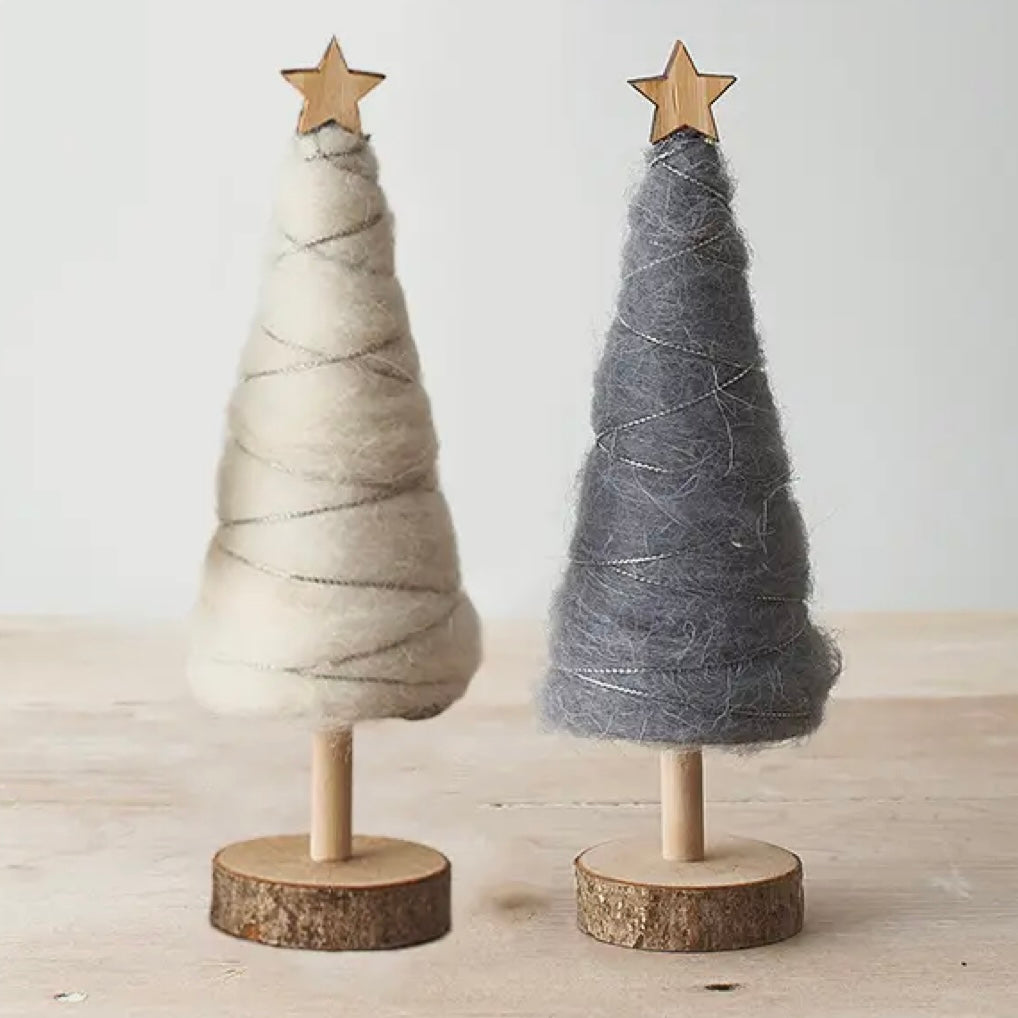 Two small decorative trees made of yarn on wooden stands with star toppers against a light background.