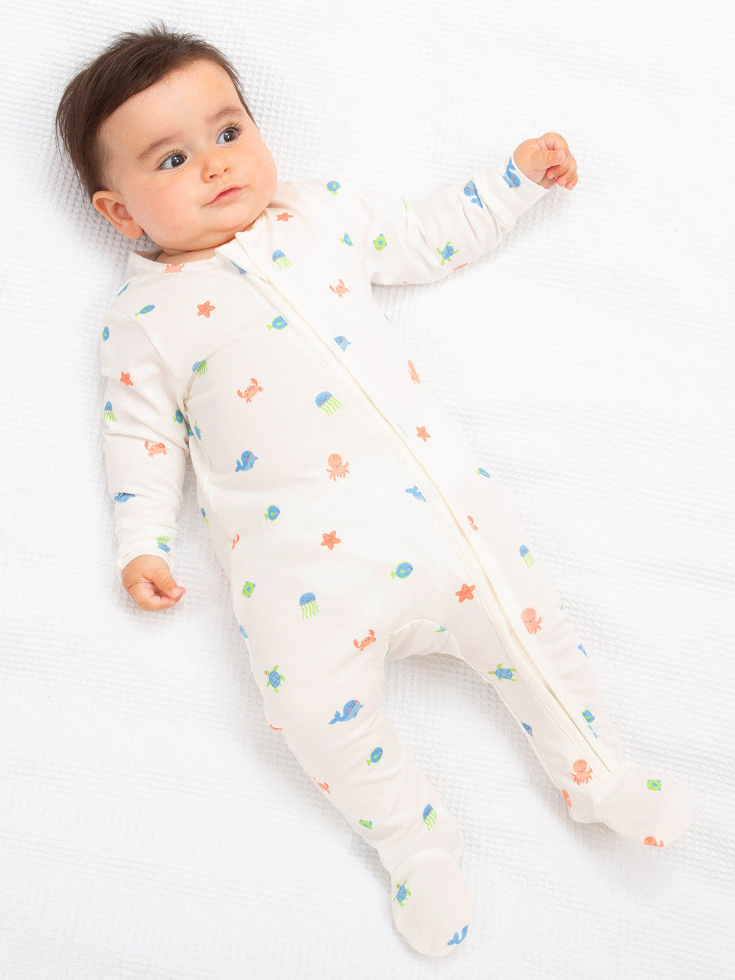 Baby wearing a white onesie with colourful patterns on a white background

Sleepsuit
Baby clothes
Organic cotton 
New baby gift
Onesie