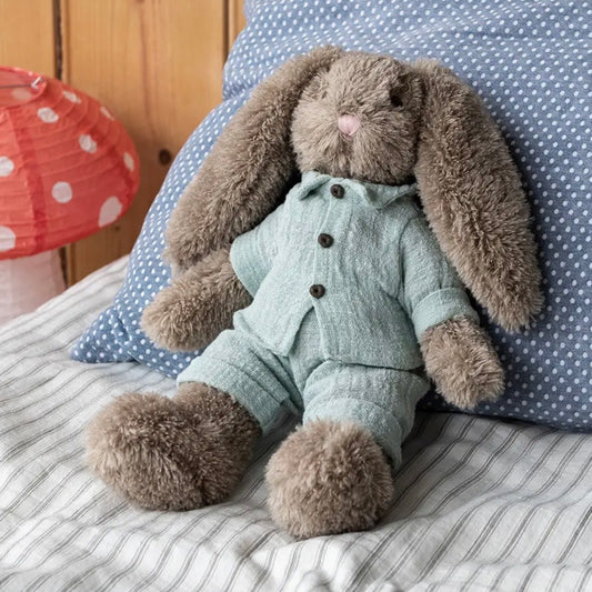A plush stuffed bunny doll with long floppy ears sits on a bed. The bunny is wearing a pale mint green button-front outfit, with a blue polka-dot pillow and striped bedding in the background.

cuddly toy rabbit, soft toy for babies, bunny stuffed animal, nursery plush toy, newborn gift toy, Easter bunny plush, comforter toy, huggable toy for toddlers,  baby shower gift, keepsake soft toy, rabbit plushie, boys soft toy