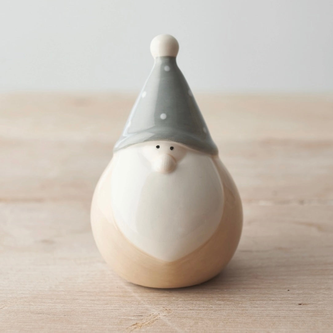 Ceramic gnome figurine with a gray hat on a wooden surface