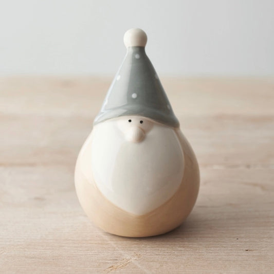 Ceramic gnome figurine with a gray hat on a wooden surface
