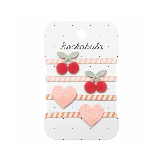 Set of four hairbands with cherry and heart designs on a Rockahula branded card.
