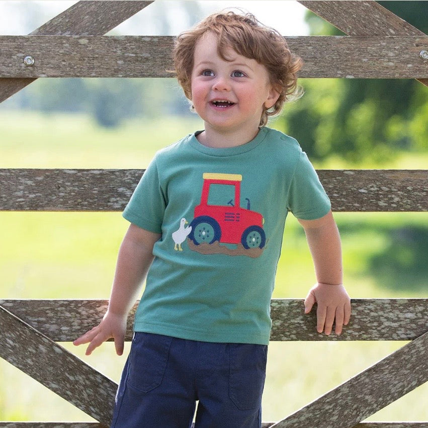 Child wearing a green t-shirt with a red tractor design, standing in front of a wooden gate.

T-Shirt
Children's clothing 
Organic cotton 
Kids clothing 
Summer outfits 