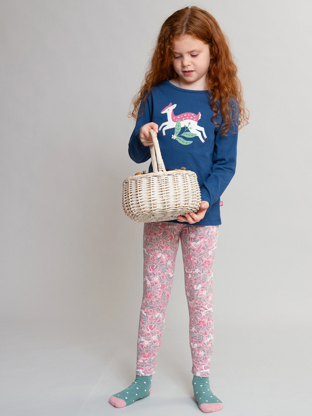 A young girl with long red hair stands against a light grey studio background, wearing a navy long-sleeve shirt with a colourful deer appliqué pink patterned leggings, and teal socks while holding a small woven basket.

T-Shirt 
Children's clothing
Organic cotton 
Navy
Deer
Kite clothing