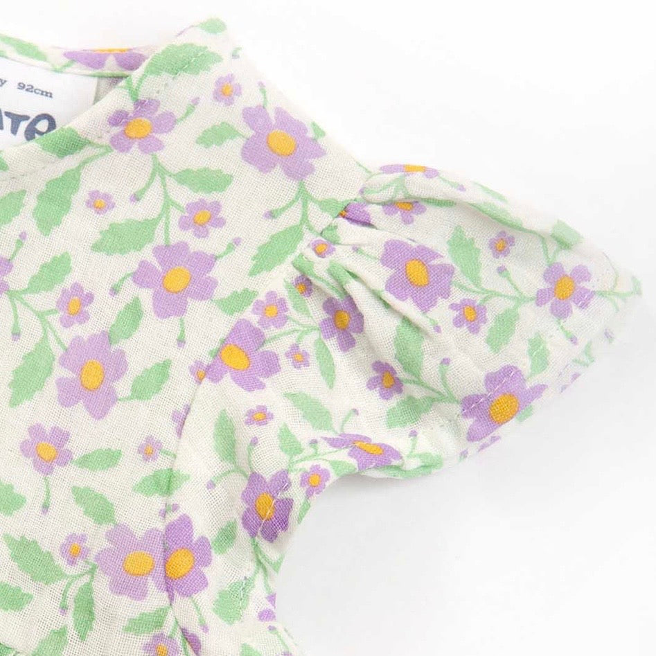 A close-up of a childs garment featuring a light purple and green floral print on a warm off-white background, with ruffled short sleeves.

Children's clothing 
Dress
Kids clothes
Floral dress
Occasion dress
GOTS Certified fabrics 
Kite clothing 