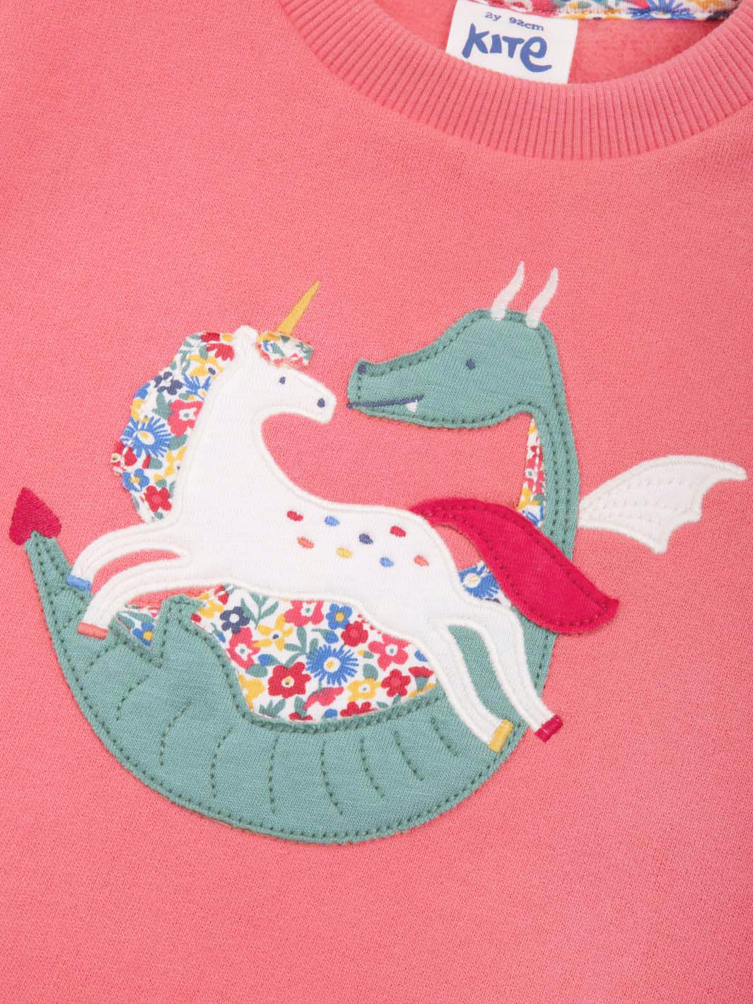 Close up of the dinosaur and unicorn appliqué on the front of our sweatshirt 