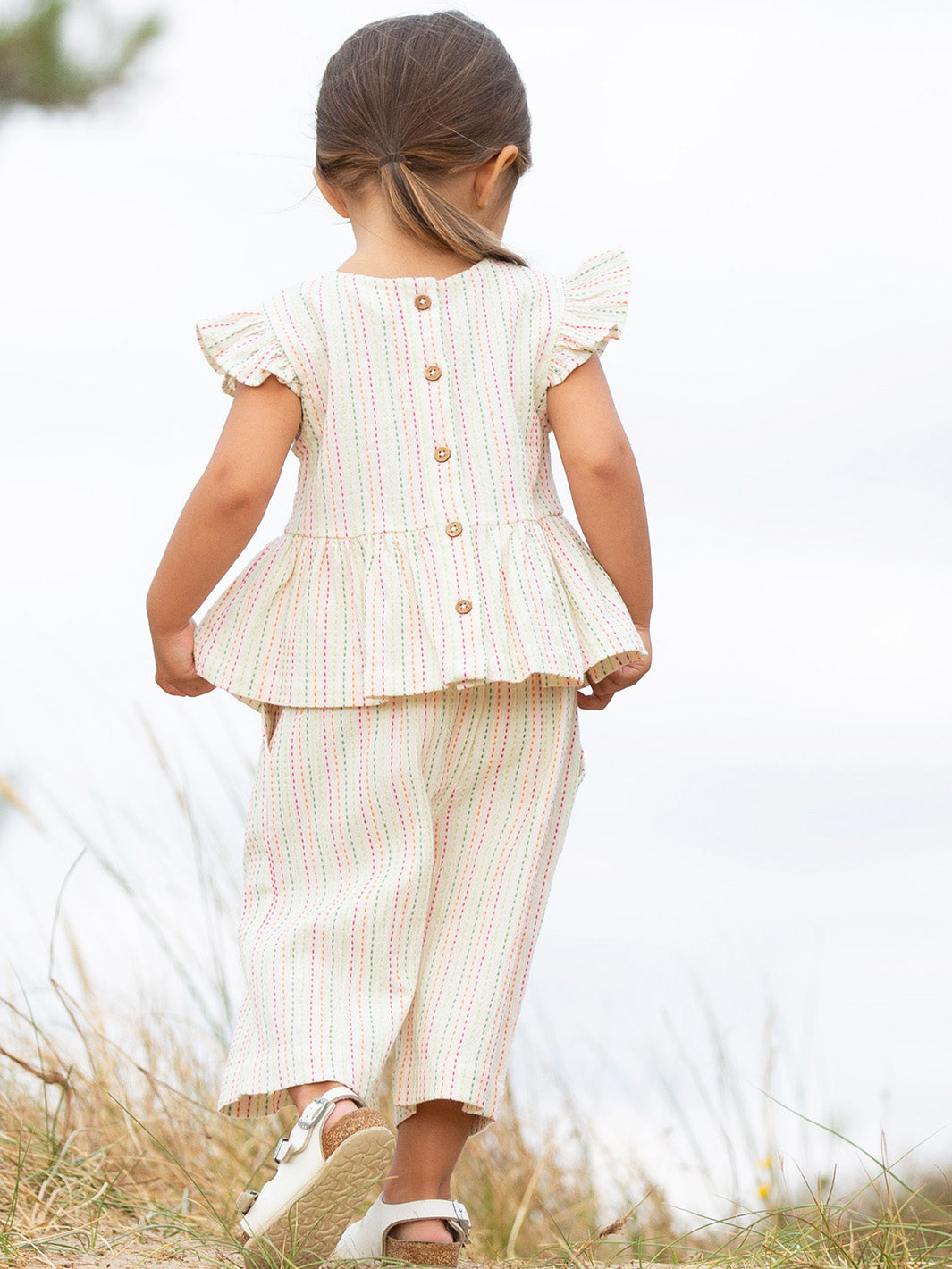 Child wearing a stripe outfit standing in a field

Children's clothing 
Kids clothes
Organic cotton 
Stripes 
Trousers
Pull Ups