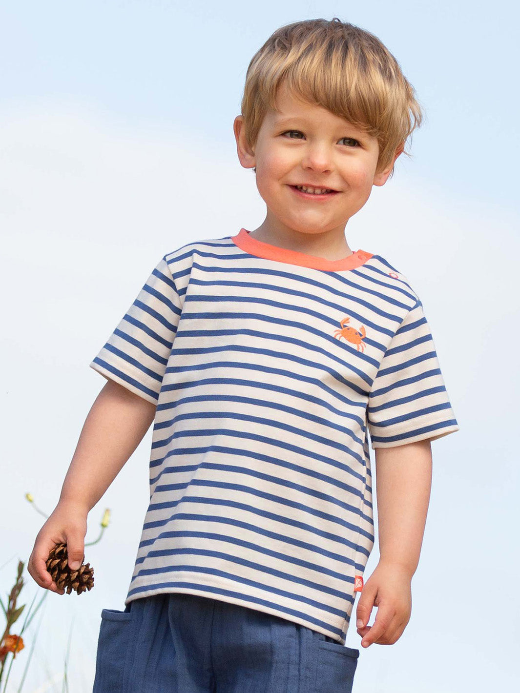 Child wearing a striped shirt with a small embroidered crab against a clear blue sky

Children's clothing 
Crab 
Stripes 
T-Shirts
Organic cotton 
