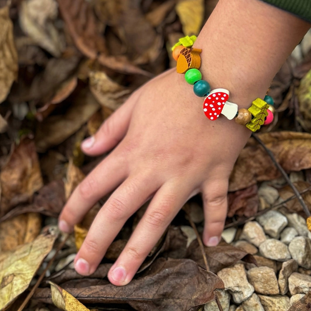 Child wearing our forest bracelet in the woods
