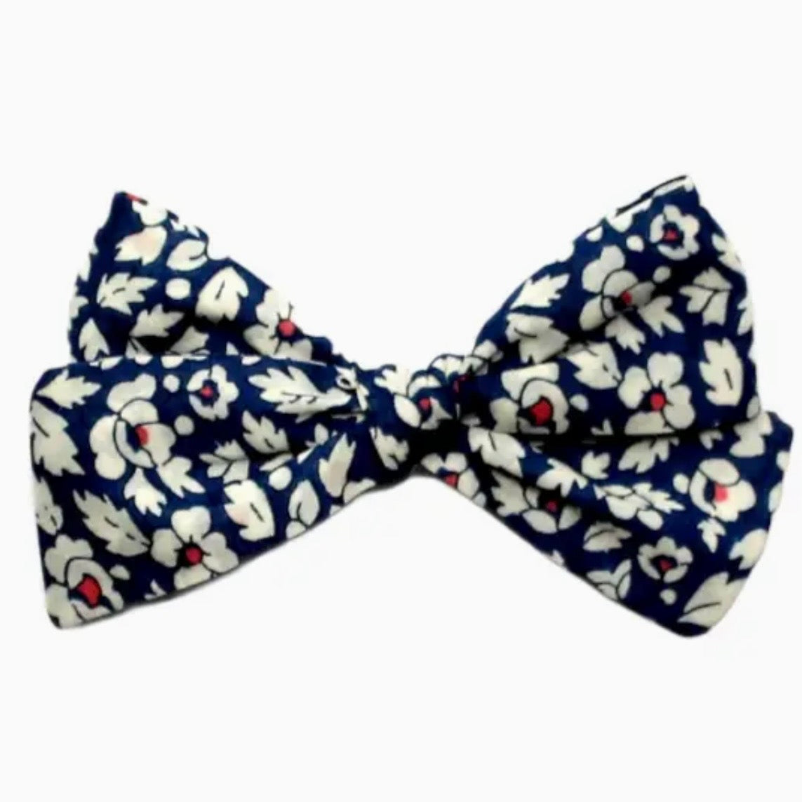 A floral bow clip tie featuring a navy blue background with a white floral pattern and small red flower centers, shown against a plain white background.

Hair Clips
Liberty Print
Gift inspiration 
Floral
Girls Hair Accessories