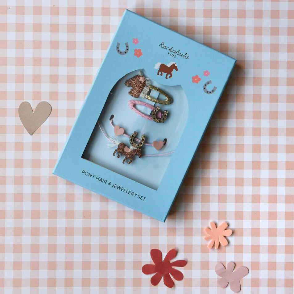 Pony hair and jewelry set in a blue box on a checkered tablecloth