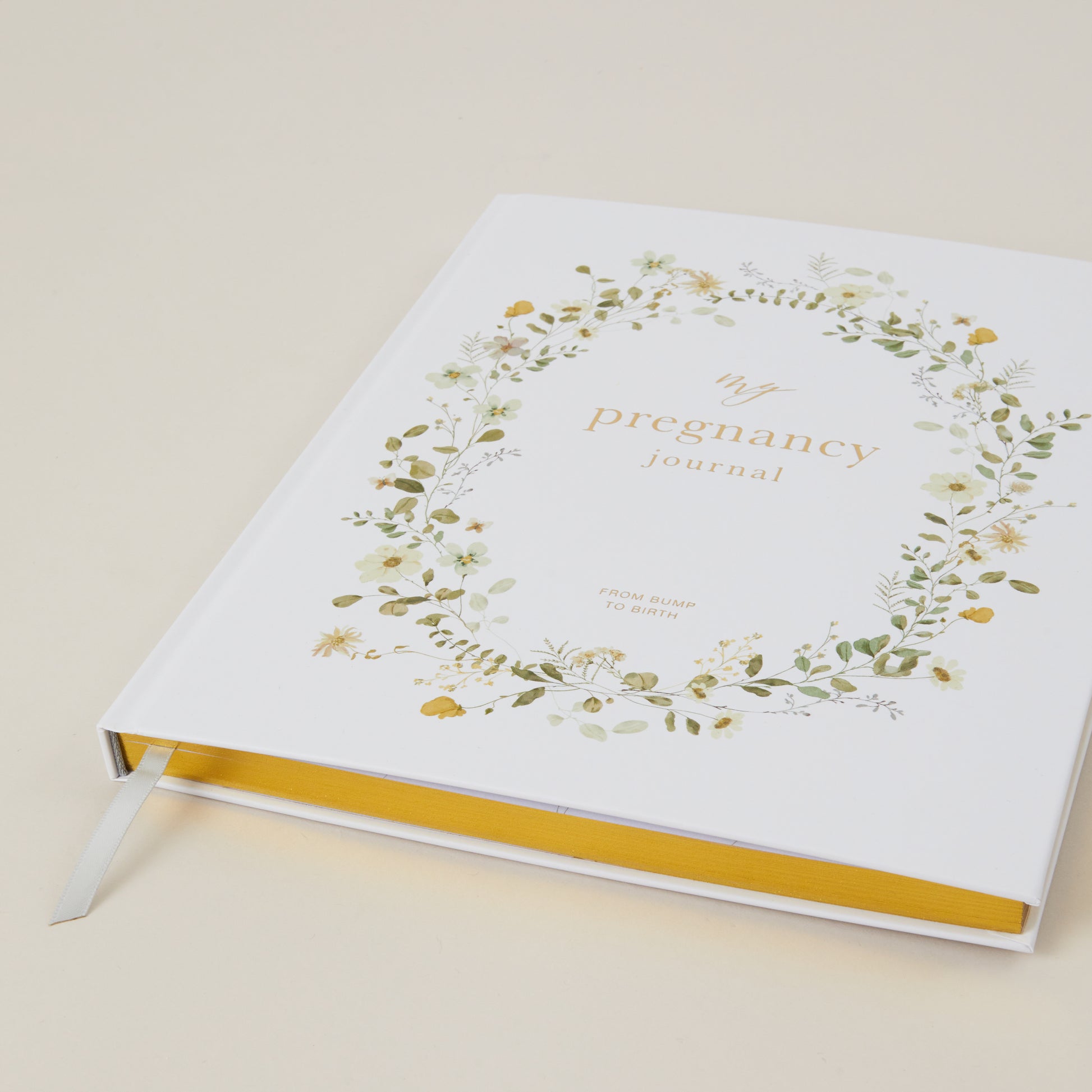 Pregnancy journal with floral design on a beige background