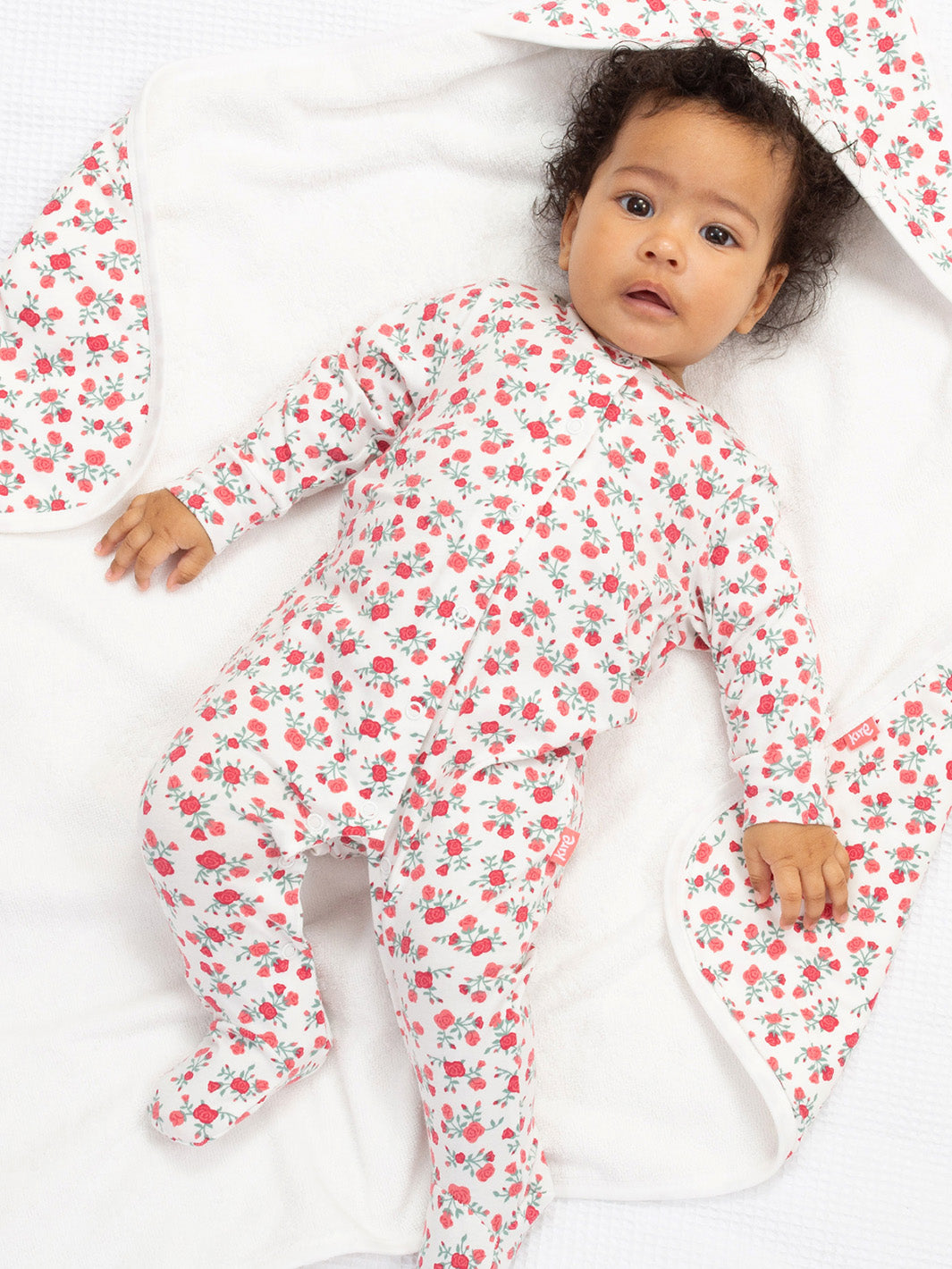 Baby wearing a sleepsuit with a rose print on a blanket