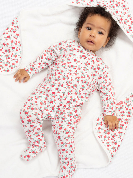 Baby wearing a sleepsuit with a rose print on a blanket