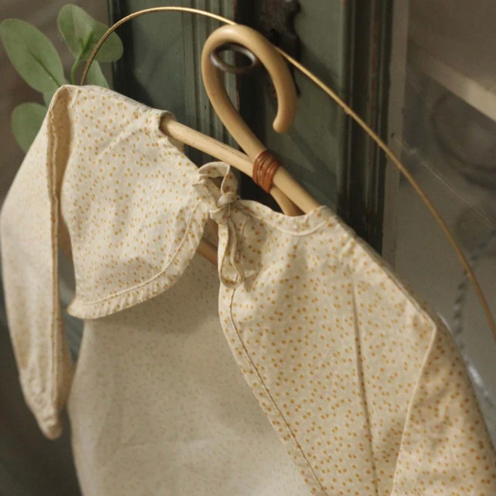 Baby bib with floral pattern on a hanger against a neutral background
A lovely new baby present 