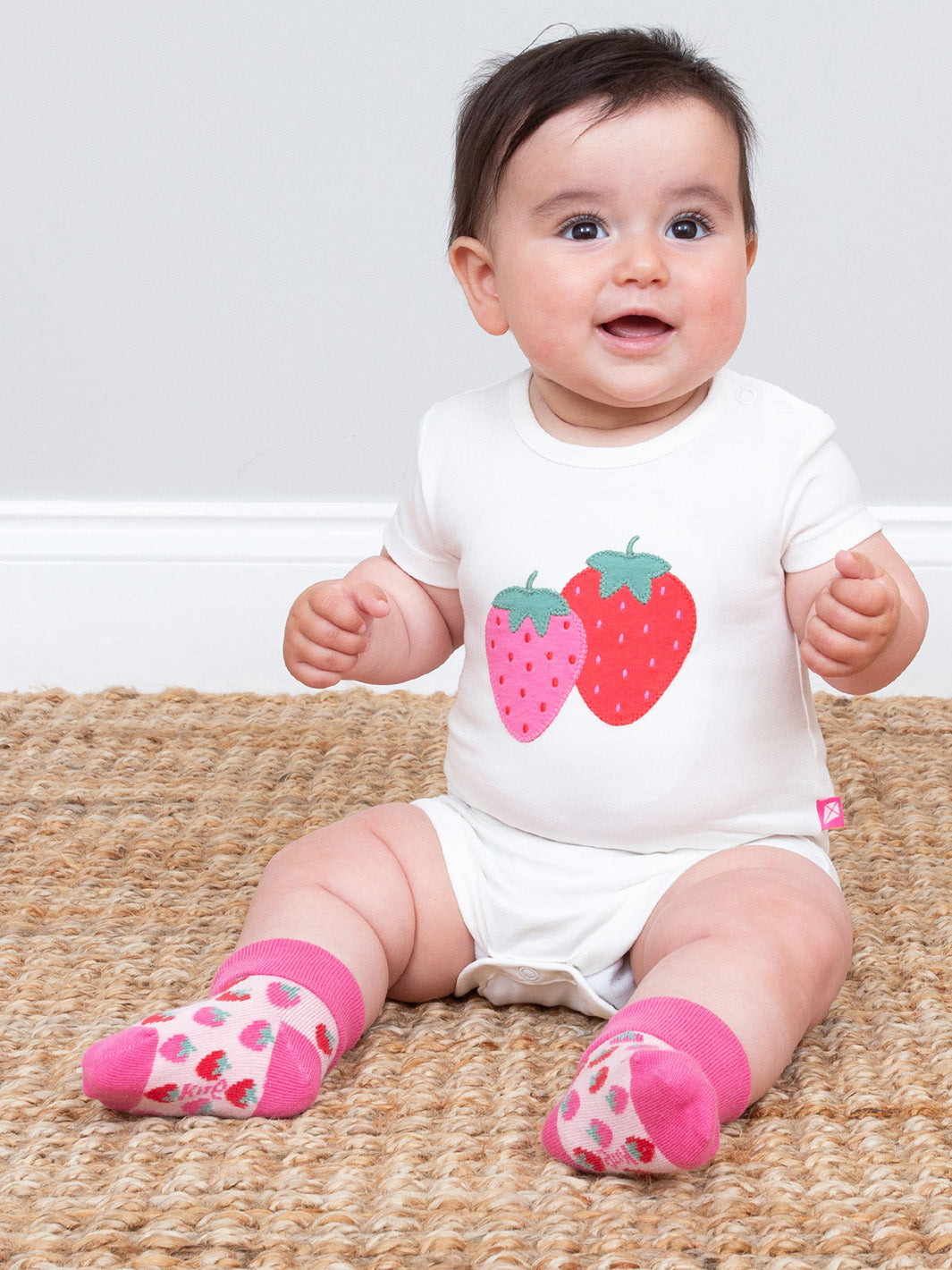 Baby wearing a bodysuit with strawberry design and pink socks on a beige rug.

Baby clothing
Strawberry 
Bodysuit 
Applique 
New baby gift
Organic cotton clothing 