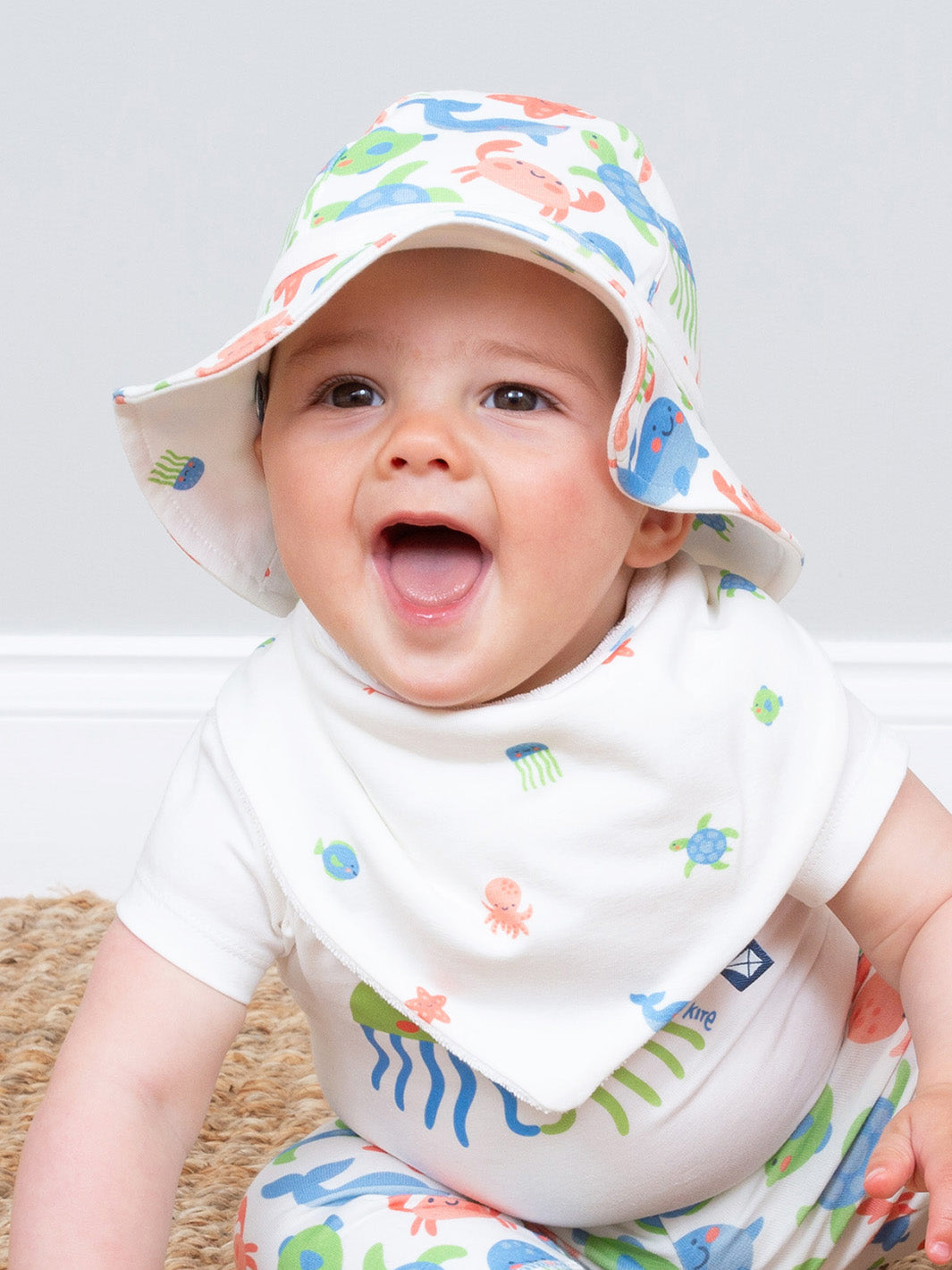 Baby wearing a colorful hat and bib with animal prints on a light background

Sun hat 
Organic cotton 
Reversible 
Baby clothing 
Summer clothing 
Summer