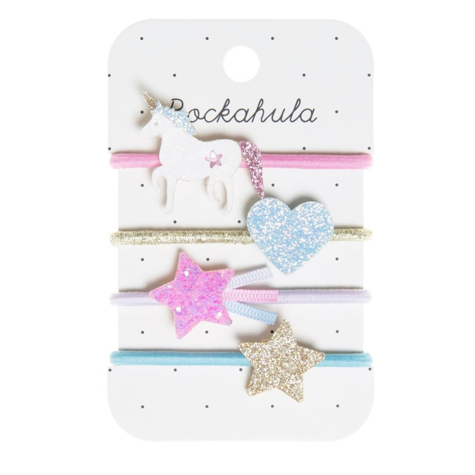 A set of four hair ponies with unicorn and star designs, displayed on a card.