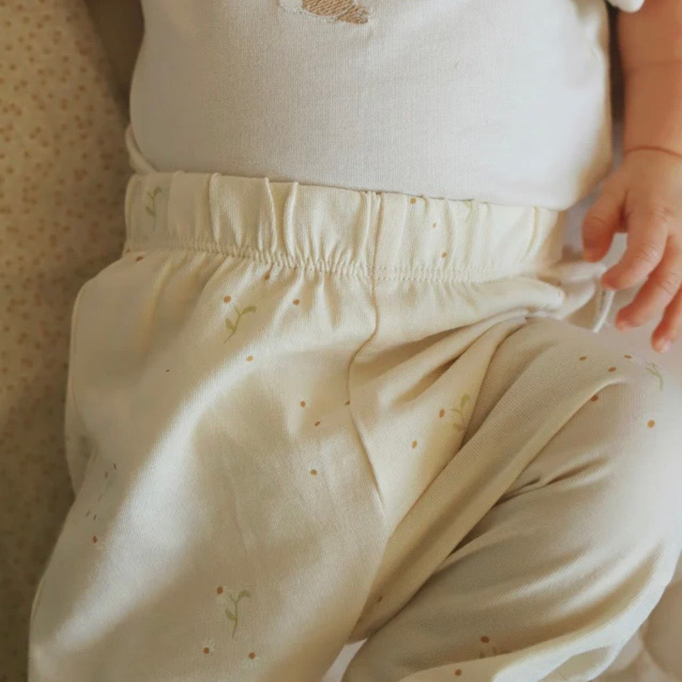 Close-up of a baby wearing light-colored leggings in our Wild Chamomile print 