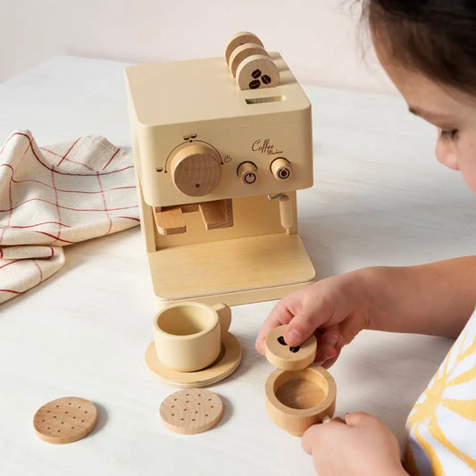 A child's wooden coffee-themed play set on a white tabletop, featuring a cream-coloured coffee machine, cups, saucers, and round wooden accessories, with a child interacting with the set.

pretend coffee shop, barista role play, kitchen playset, imaginative play, cafe toy, wooden play kitchen accessory, pretend drinks toy, portafilter toy, biscotti toy, hand-eye coordination toy